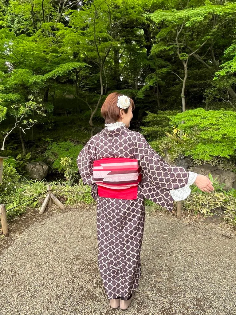 庭園で着物姿の女性の後ろ姿、髪に白い花飾り