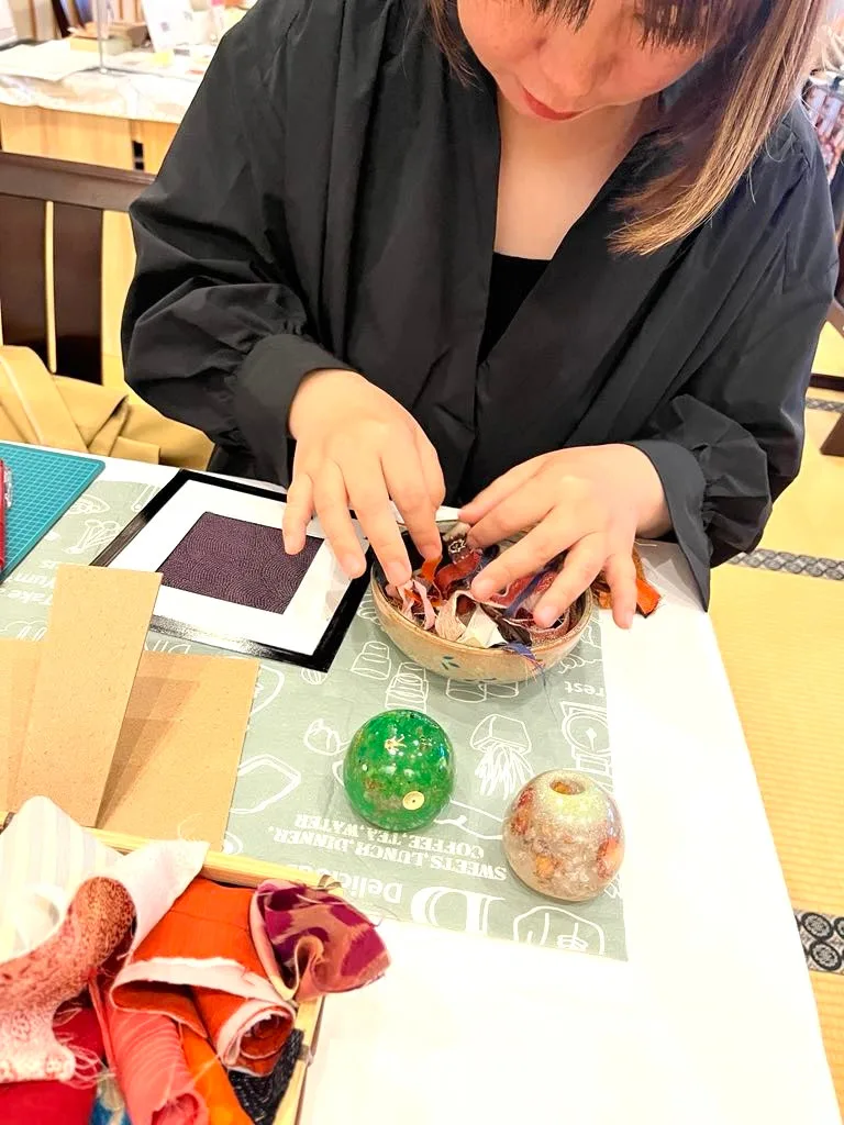 生地や小物を手に取りながら制作する福島晴美の様子